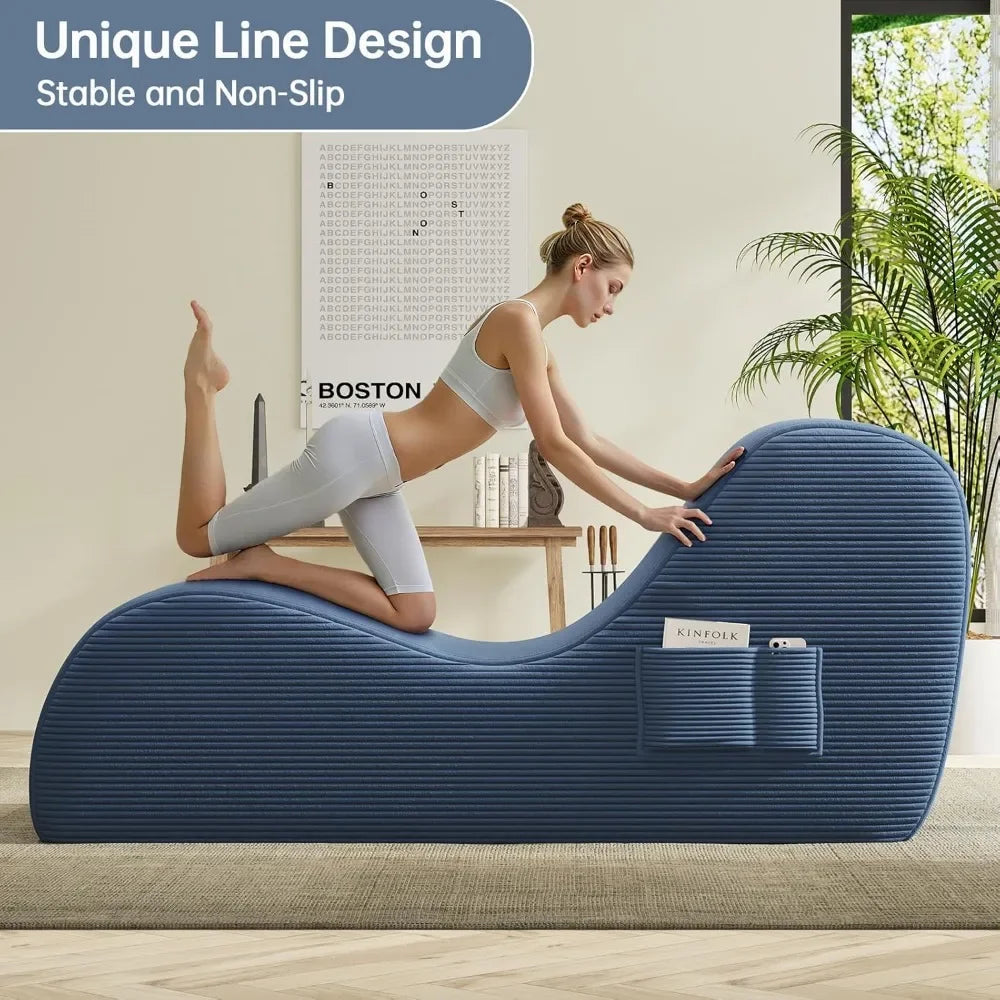 Woman using a blue exercise roller on a wooden floor with a plant and wall art in the background.